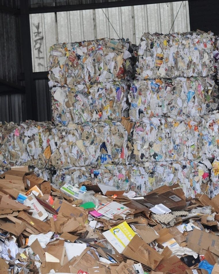 Fardos de papel y cartón apilados en un centro de acopio